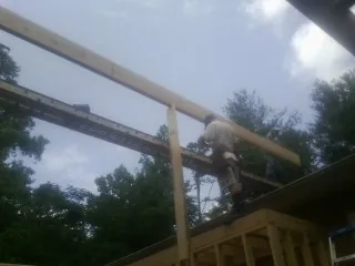 Carpenter setting a ridge beam over a new addition frame — Ice Dam Removal by Roofing Brothers in East Petersburg