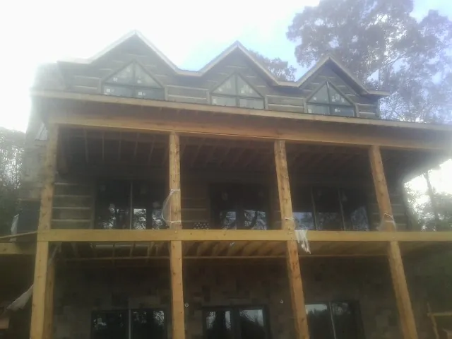 Dormers and porch framing on a large log home under construction — Roof Coating work by our crew in East Petersburg