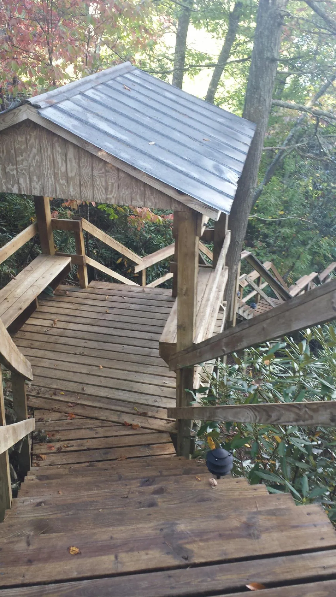 Metal roofed shelter over wooden steps on a wooded walkway — Skylight Repair & Installation work by our crew in East Petersburg