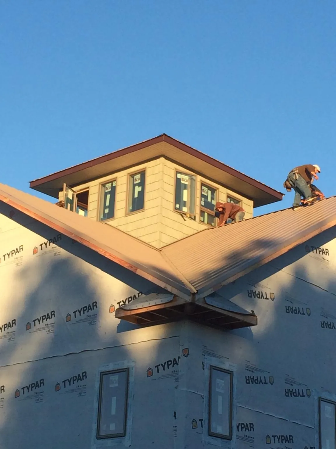 Roofers working around a rooftop cupola on a new metal roof at sunset — Roof Waterproofing in East Petersburg by Roofing Brothers